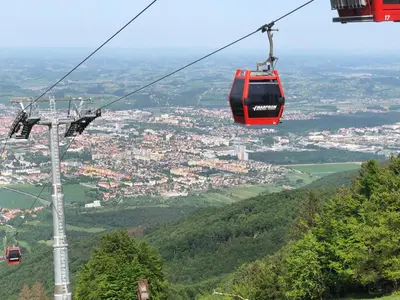 a gondola ride in the sky over a city at Hotel Bajt Maribor in Maribor