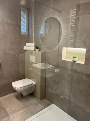 a bathroom with a toilet and a glass shower at Hotel Bajt Maribor in Maribor