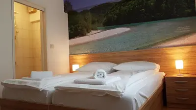 a bedroom with two beds with a painting on the wall at B&B By The Way in Ljubljana