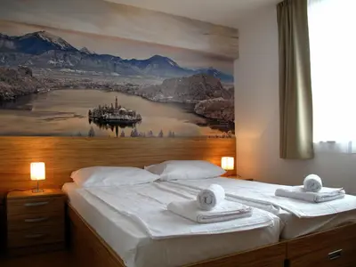 a bedroom with a bed with a painting on the wall at B&B By The Way in Ljubljana