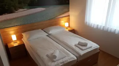 a bedroom with a bed with white sheets and pillows at B&B By The Way in Ljubljana