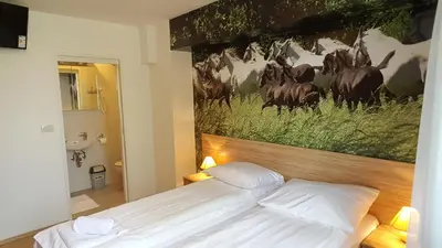 a bedroom with a bed with a painting on the wall at B&B By The Way in Ljubljana