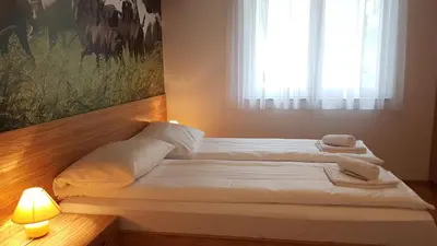 a bed with white sheets and pillows in a room with a window at B&B By The Way in Ljubljana