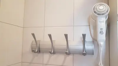 a bathroom wall with a hair dryer and five knives at B&B By The Way in Ljubljana