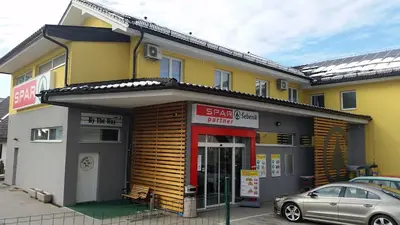 a yellow building with a sign in front of it at B&B By The Way in Ljubljana