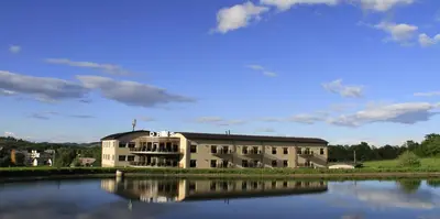a large building next to a body of water at Hotel DRAŠ in Maribor