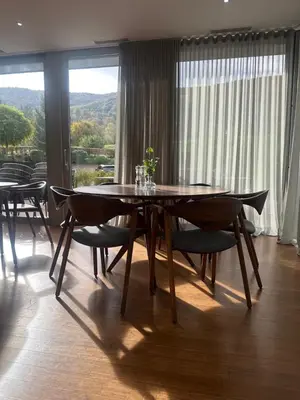 a dining room with a table and chairs and a window at Hotel DRAŠ in Maribor