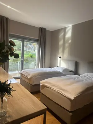 a hotel room with two beds and a window at Hotel DRAŠ in Maribor