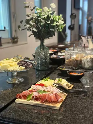 a table with plates of food on a counter at Hotel DRAŠ in Maribor