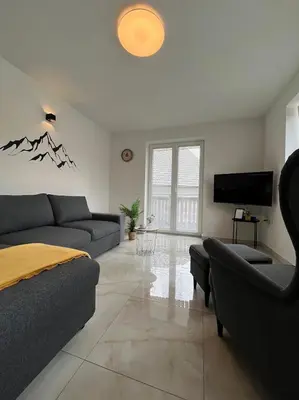 a living room with a couch and a tv at Apartments Julian Experience in Rateče