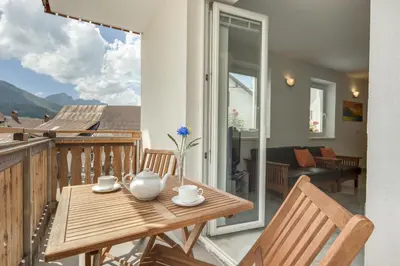 a wooden table and chairs on a balcony at Apartments Julian Experience in Rateče