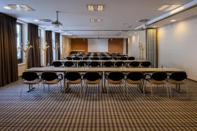 a conference room with a large table and chairs at Wellness Hotel Montis in Mozirje