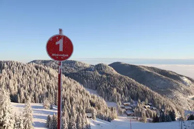 a red sign on top of a snow covered mountain at Wellness Hotel Montis in Mozirje