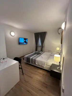 a bedroom with a bed and a tv on the wall at Hotel Paquito in Nova Gorica