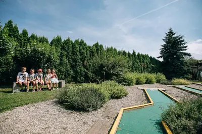 a group of people sitting on a bench next to a pond at Gostilna in motel Pri Lešniku in Maribor