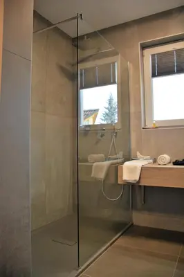 a glass shower in a bathroom with a sink at Gostilna in motel Pri Lešniku in Maribor