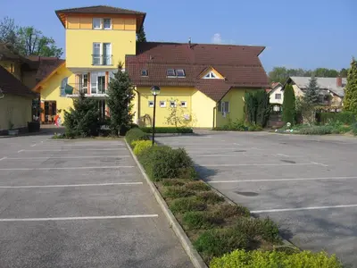 a parking lot in front of a yellow building at Gostilna in motel Pri Lešniku in Maribor