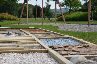 a park with a playground with rocks and a swing at Gostilna in motel Pri Lešniku in Maribor
