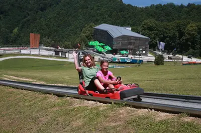 a woman and a child riding on a toy train at Hotel Celjska Koca in Celje