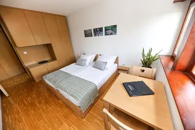 a small room with a bed and a desk at Hotel Celjska Koca in Celje