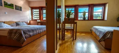 a bedroom with two beds and a table with a chair at Hotel Celjska Koca in Celje