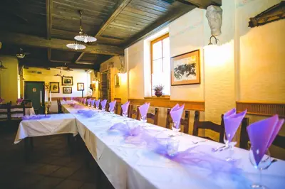 a long table with white tables and chairs in a room at Hotel Kovac in Osilnica
