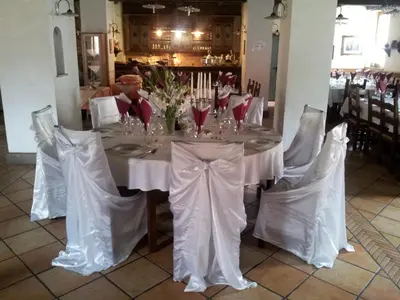 a table with white table cloths and flowers on it at Hotel Kovac in Osilnica