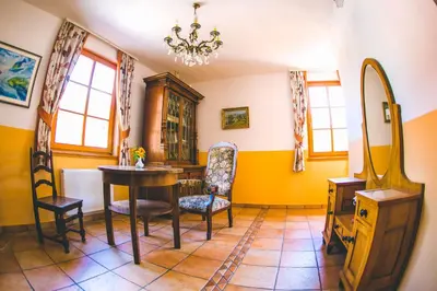 a dining room with a table and chairs and a mirror at Hotel Kovac in Osilnica