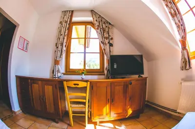 a room with a desk with a tv and a window at Hotel Kovac in Osilnica