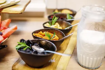 a table with bowls of food and a glass of milk at Bit Center Hotel in Ljubljana