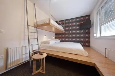 a bedroom with a bunk bed with a ladder at Bit Center Hotel in Ljubljana