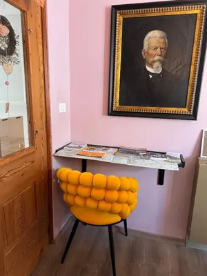 a painting of a man on a table with a yellow chair at Vila Alice Bled - Adults only in Bled