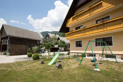 a playground in a yard in front of a building at Apartmaji Matej Cvetek in Bohinj