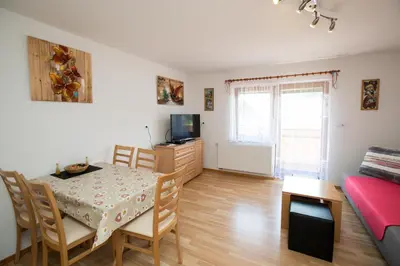 a living room with a table and a dining room at Apartmaji Matej Cvetek in Bohinj