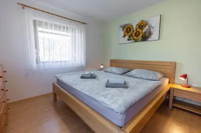 a bedroom with a large bed with two pillows on it at Apartmaji Matej Cvetek in Bohinj