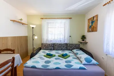 a bedroom with a bed with a blue comforter at Apartmaji Matej Cvetek in Bohinj