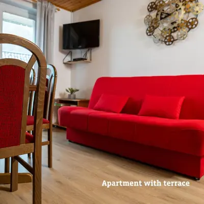 a red couch with red pillows in a living room at Apartmaji Taler in Bohinj