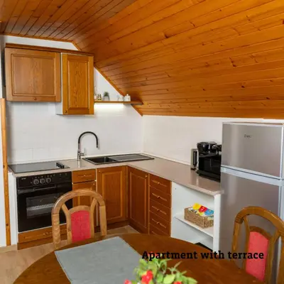 a kitchen with wooden cabinets and a white refrigerator at Apartmaji Taler in Bohinj