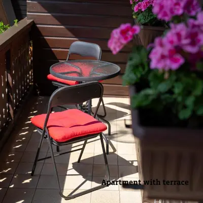 two chairs and a table on a patio with flowers at Apartmaji Taler in Bohinj