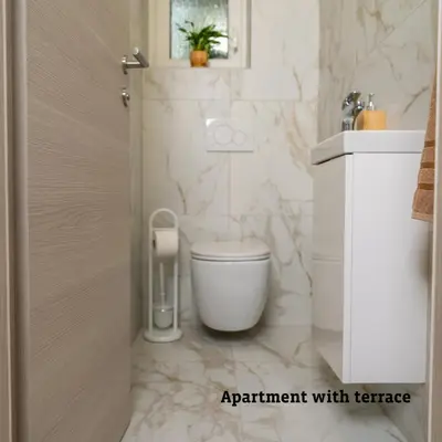 a white bathroom with a toilet and a sink at Apartmaji Taler in Bohinj