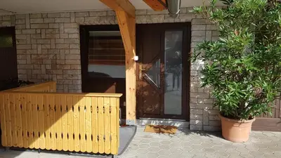 a front door of a house with a cat in front at Apartmaji Taler in Bohinj