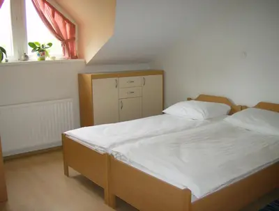 a bedroom with a bed with white sheets and a window at Apartments Vita Center in Rogaška Slatina