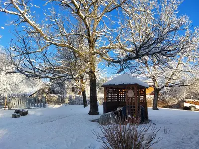 a gazebo in the snow next to a tree at Apartments Vita Center in Rogaška Slatina