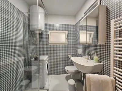 a bathroom with a sink and a toilet and a mirror at Jager Apartments Tour As Ljubljana in Ljubljana