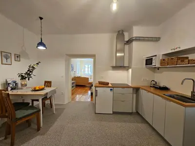 a kitchen with white cabinets and a table with a sink at Jager Apartments Tour As Ljubljana in Ljubljana