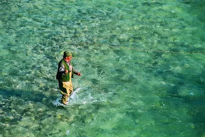a man standing in the water holding a kite at Apartment Honey Bee with SAUNA in Kobarid