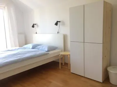 a bedroom with a bed and a white cabinet at Guest House Vitaja in Bled