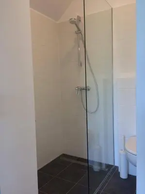 a bathroom with a glass shower with a toilet at Guest House Vitaja in Bled