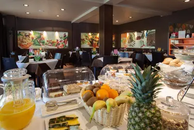 a table with food and fruit on it in a restaurant at Hotel Pomaranča in Ptuj