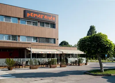 a restaurant with tables and chairs in front of a building at Hotel Pomaranča in Ptuj